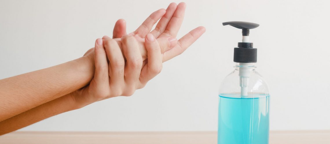 Asian woman using alcohol gel hand sanitizer wash hand for protect coronavirus. Female push alcohol bottle to clean hand for hygiene when social distancing stay at home and self quarantine time.